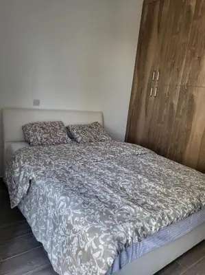 a bed with a wooden headboard in a bedroom at Limassol mountain and sea views in Limassol