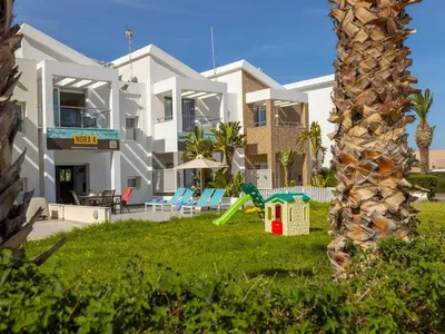 a large white house with a playground in the yard at Villa Nora in Protaras