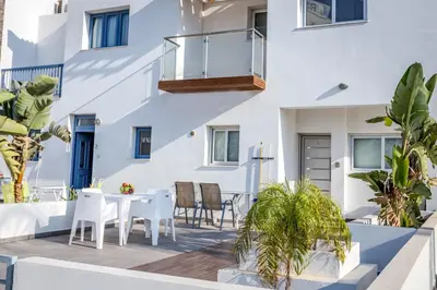 a patio with a table and chairs in front of a building at Villa Nora in Protaras