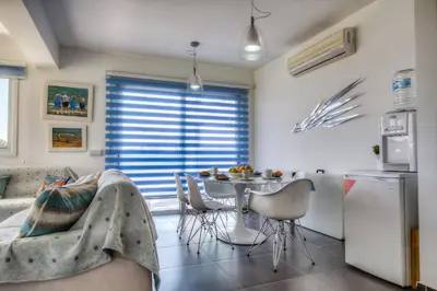 a kitchen with a table and chairs in a room at Beachfront Trident in Protaras
