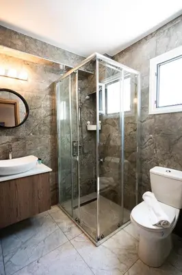 a bathroom with a shower and a toilet and a sink at Luca Apts Napa in Ayia Napa