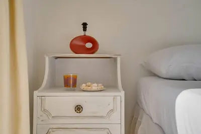a nightstand with a plate of eggs on it next to a bed at Ammos Villa 20 Side Seaview in Larnaka