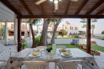 a table and chairs on a patio with a view of the ocean at Ammos Villa 20 Side Seaview in Larnaka