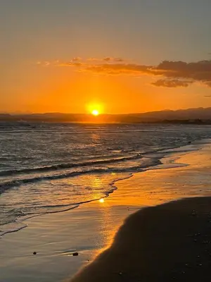 a sunset on the beach with the sun setting at Ammos Villa 20 Side Seaview in Larnaka