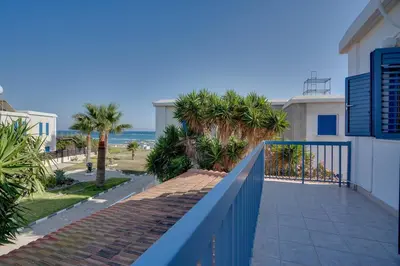 a balcony with a blue fence and the beach at Ammos Villa 20 Side Seaview in Larnaka