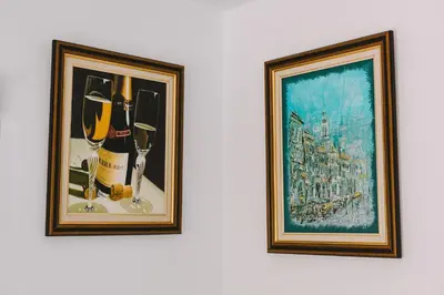 two framed pictures of wine bottles and glasses on a wall at Neapolis Residence Spacious Quiet Near beach in Limassol