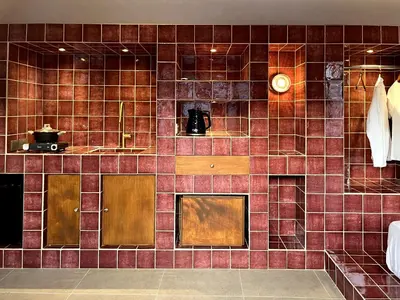 a tiled wall in a kitchen with a clock on it at Stin Avli tou Pavlou Guest House in Omodos
