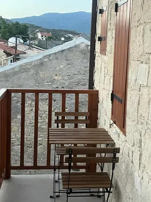 a wooden bench sitting on a balcony with a view at Stin Avli tou Pavlou Guest House in Omodos