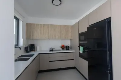 a kitchen with white counters and a black refrigerator at Semeli Villa 8 in Protaras