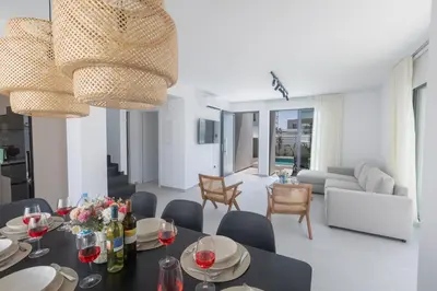 a dining room and living room with a table and chairs at Semeli Villa 8 in Protaras
