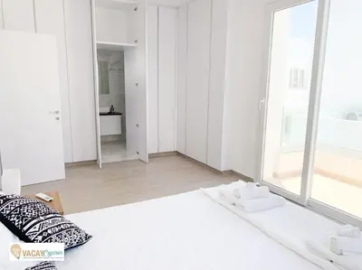 a white room with a bed and a large window at Villa Orash in Larnaka