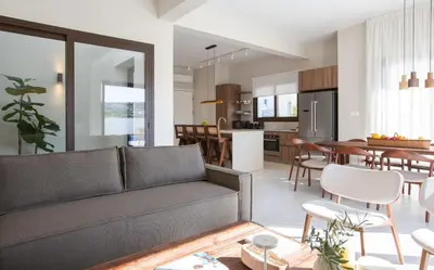 a living room and kitchen with a couch and a table at LIV & CO Suites & Villas in Voroklini