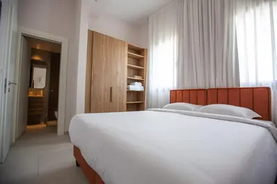 a bedroom with a large white bed and a window at LIV & CO Suites & Villas in Voroklini