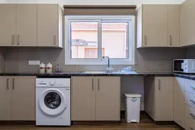 a kitchen with a washing machine and a window at Aura 2-Bedroom Apartment in Larnaca in Larnaka