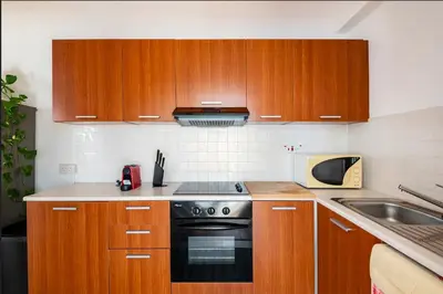 a kitchen with wooden cabinets and a stove top oven at Top Floor Apartment City Center in Larnaka