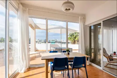 a dining room with a table and chairs and a balcony at Top Floor Apartment City Center in Larnaka