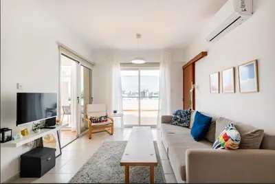 a living room with a couch and a tv at Top Floor Apartment City Center in Larnaka