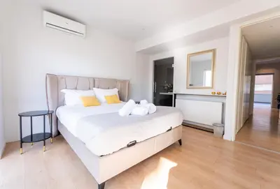 a bedroom with a large white bed with yellow pillows at Deluxe Downtown with spacious balcony in Nicosia
