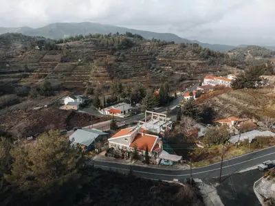 an aerial view of a small village on a hill with a road at Kyperounta Troodos mountain house in Limassol