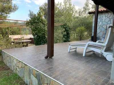a porch with two white chairs and a stone wall at Mountain View! Cosy life in Nicosia