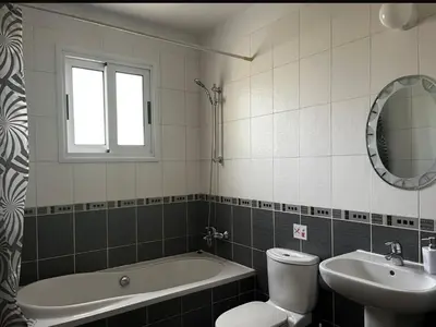 a bathroom with a tub and a toilet and a sink at Hana Nissi in Ayia Napa