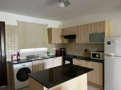 a kitchen with a refrigerator and a washer and dryer at Hana Nissi in Ayia Napa