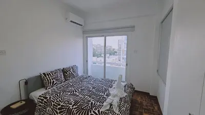 a bedroom with a bed and a large window at STAY City Life Apartment I in Nicosia