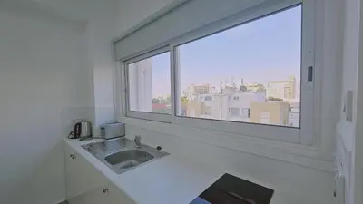 a white bathroom with a sink and a window at STAY City Life Apartment I in Nicosia