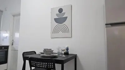 a black table with two chairs and a picture on the wall at STAY City Life Apartment I in Nicosia