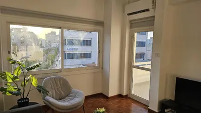 a living room with a chair and a large window at STAY City Life Apartment I in Nicosia