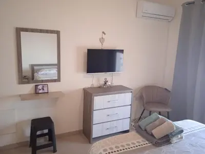 a bedroom with a dresser with a tv and a chair at Xylophagou Rest and Relax 4 Top floor Big Balcony 1 bedroom apartment in Xylophaghou