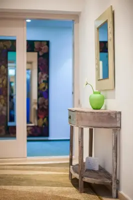 a table with a green vase on it in a room at Operetta House in Larnaka