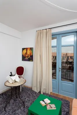 a living room with a blue door and a table at Operetta House in Larnaka