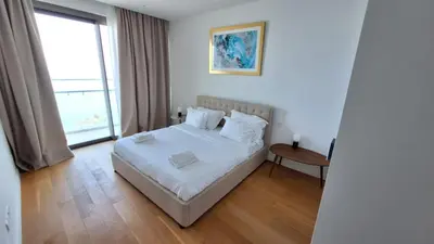 a bedroom with a white bed and a large window at Del Mar 2 Bedroom Deluxe Seaside 'A' Residence in Limassol