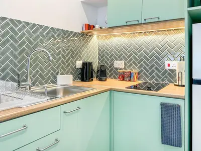 a kitchen with blue cabinets and a sink at Terrazzo style 2 bedroom 2bathroom Apartment in Larnaka