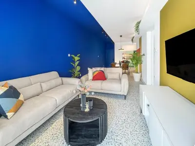 a living room with a couch and a blue wall at Terrazzo style 2 bedroom 2bathroom Apartment in Larnaka