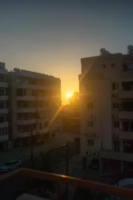 a sunset seen from a balcony of a building at Maestro Sunrise View in Larnaka