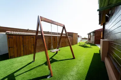 a swing set on a balcony with green grass at Ktima To Alliotiko - Lofou 1 in Lofou