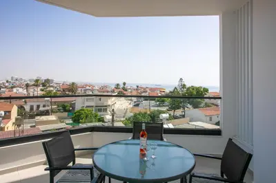 a room with a table and chairs and a large window at Palmove Newly Build Seaview Apt in Larnaka