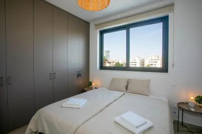 a bedroom with a large bed with two towels on it at Palmove Newly Build Seaview Apt in Larnaka