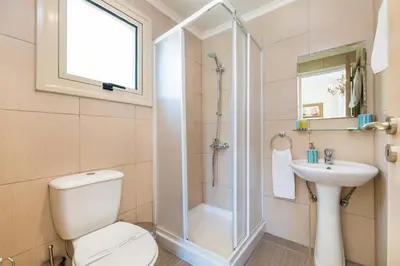 a bathroom with a shower and a toilet and a sink at Villa Jacqueline in Protaras