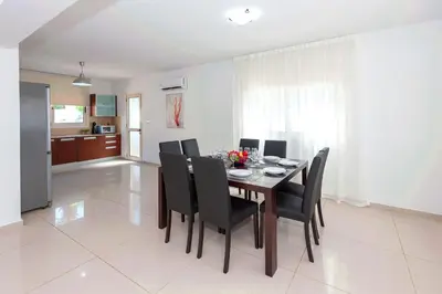 a dining room with a table and black chairs at Villa Anemona - 100m from Pernera Beach in Protaras