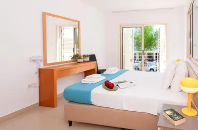 a bedroom with a bed with a mirror and a table at Villa Anemona - 100m from Pernera Beach in Protaras