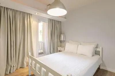 a white bedroom with a white bed and a window at Agia Napa three bedroom modern flat in Ayia Napa