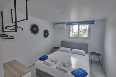 a white bedroom with a bed with towels on it at Gold Emerging Villas Ltd Apart 1 in Ayia Napa