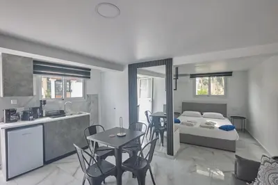 a bedroom with a bed and a kitchen with a table at Gold Emerging Villas Ltd Apart 1 in Ayia Napa