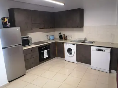 a kitchen with a white refrigerator and a dishwasher at Yippee! at Ermou Square Amazing Location View in Larnaka