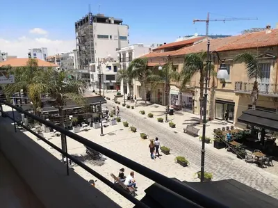 a group of people walking around a city street at Yippee! at Ermou Square Amazing Location View in Larnaka