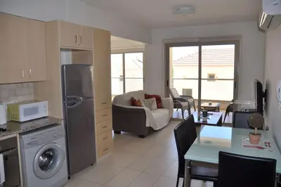 a kitchen and living room with a couch and a table at Ivory Suite at Polyxenia - Tourism licence 03125 in Protaras