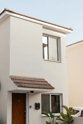 a white house with a brown door at Leah's Deluxe Villa in Tersephanou